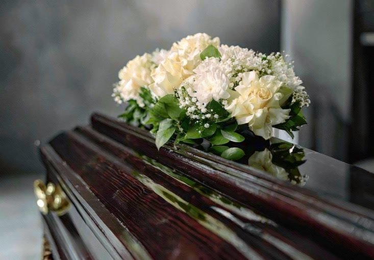White flowers resting on a polished casket